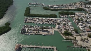 AX0026_012 - 5K stock footage aerial video of boats docked at a coastal marina, Marathon, Florida