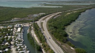 AX0026_045E - 5K stock footage aerial video of following Overseas Highway past Big Pine Key Fishing Lodge, Big Pine Key, Florida