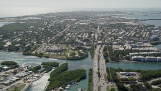 AX0026_059 - 5K aerial stock footage of following Overseas Highway, approaching the shore of Key West, Florida