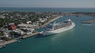 AX0026_069E - 5K aerial stock footage of orbiting a Royal Caribbean Cruise Ship docked in Key West, Florida
