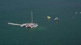 AX0026_086E - 5K aerial stock footage of flying over swimmers, floats, off the shore of Key West, Florida