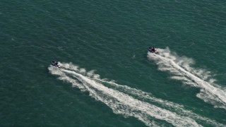 AX0026_089E - 5K aerial stock footage of tracking jet skier racing across the ocean in Key West, Florida