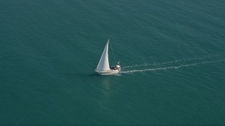 AX0026_096E - 5K aerial stock footage of following a sailboat near the shore of Key West, Florida