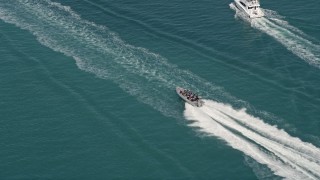 AX0026_101 - 5K aerial stock footage of tracking speedboat racing across water by Key West, Florida