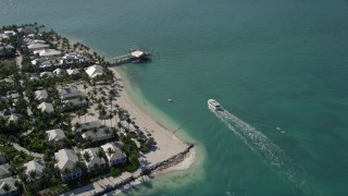 AX0026_102 - 5K aerial stock footage of a ferry nearing a pier on Sunset Key by Key West, Florida