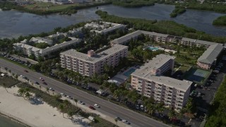 AX0027_005 - 5K aerial stock footage of following coast toward apartment buildings, Sheraton Suites, Key West, Florida