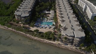 AX0027_006 - 5K aerial stock footage of following the coast, revealing 1800 Atlantic Vacation Rentals, Key West, Florida