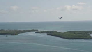 AX0027_036 - 5K aerial stock footage of tracking an F-18 landing at Naval Air Station Key West, Key West, Florida