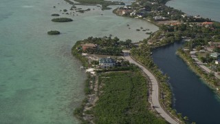 AX0027_044 - 5K aerial stock footage of flying by homes on the shore, Shark Key, Florida