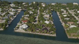 AX0027_050 - 5K aerial stock footage of approaching homes on the island shore, Lower Sugarloaf Key, Florida