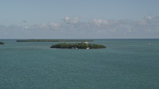 AX0027_066 - 5K aerial stock footage of flying by small island with a home, Summerland Key, Florida