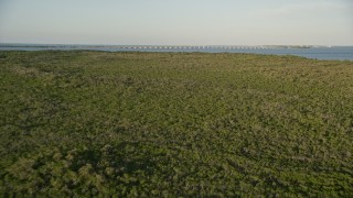 AX0028_016 - 5K aerial stock footage of flying over mangroves, approaching Overseas Highway bridge, Long Key, Florida, sunset