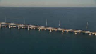AX0028_021 - 5K aerial stock footage of tracking light traffic on Overseas Highway bridge at sunset, Craig Key, Florida