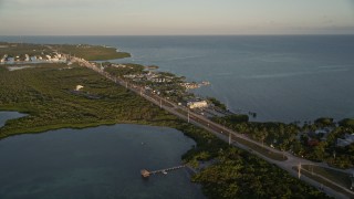 AX0028_023 - 5K aerial stock footage of Overseas Highway by Drop Anchor Resort and Marina, Islamorada, Florida, at sunset