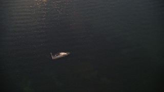 AX0028_036 - 5K aerial stock footage of orbiting a sunken speedboat at sunset, Key Largo, Florida