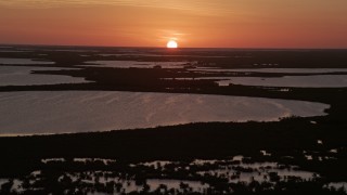 AX0028_045E - 5K aerial stock footage of descending toward the water and mangrove islands, Key Largo, Florida, sunset