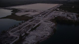 AX0028_060E - 5K aerial stock footage of approaching quarry, Homestead, Florida, twilight