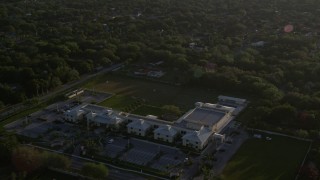 AX0029_003 - 5K aerial stock footage of approaching Riviera Preparatory School in Kendall, Florida, sunrise