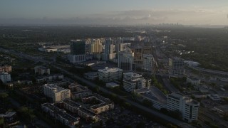 AX0029_004E - 5K aerial stock footage of approaching and flying by office buildings, Kendall, Florida, sunrise