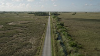AX0030_044E - 5K aerial stock footage of following a country road, Florida Everglades, Florida