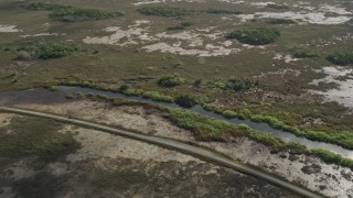 AX0030_058 - 5K aerial stock footage of flying by country road and marshland, Florida Everglades, Florida