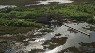 AX0030_061E - 5K aerial stock footage of orbiting huts and dock on marshland, Florida Everglades, Florida