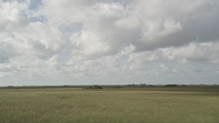 AX0030_095 - 5K aerial stock footage of flying by low clouds over the marshland, Florida Everglades, Florida