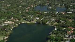 AX0031_003 - 5K aerial stock footage of flying over a lake toward homes on the shore, Coral Gables, Florida