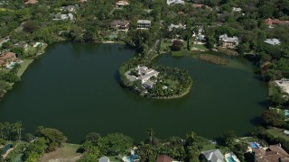 AX0031_004 - 5K aerial stock footage fly over Hammock Lake, approach island mansion, tilt down, Coral Gables, Florida