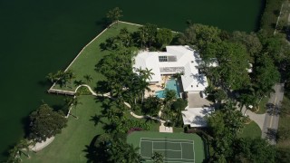 AX0031_007 - 5K aerial stock footage of flying over a mansion by the water, Coral Gables, Florida