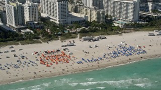 AX0031_054 - 5K aerial stock footage of flying by sunbathers, South Beach, Miami Beach, Florida