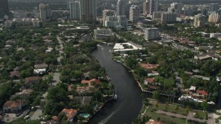 AX0031_113 - 5K aerial stock footage of following New River past mansions, revealing Downtown Fort Lauderdale, Florida