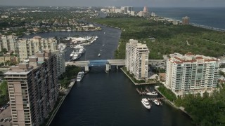 AX0031_136E - 5K aerial stock footage follow canal past apartments, East Sunrise Boulevard bridge, Fort Lauderdale, Florida