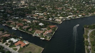 AX0031_140 - 5K aerial stock footage of following canal, tilt down on mansions, Fort Lauderdale, Florida