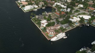 AX0031_141 - 5K aerial stock footage of approaching mansion by canal and a yacht, tilt down, Fort Lauderdale, Florida