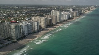 AX0031_143E - 5K stock footage aerial video of flying by apartment buildings, revealing beach, coastline, Fort Lauderdale, Florida