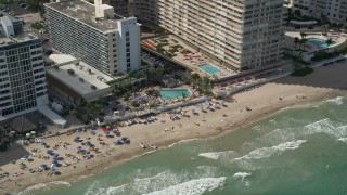 AX0031_145 - 5K aerial stock footage of sunbathers by Ocean Sky Hotel and Resort, Fort Lauderdale, Florida