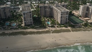 AX0031_147 - 5K aerial stock footage of flying by apartment buildings, sunbathers, Lauderdale by the Sea, Florida