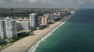 AX0031_149E - 5K aerial stock footage of following the beach past apartment complexes, Lauderdale by the Sea, Florida