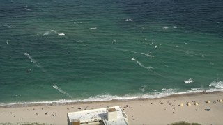 AX0031_164E - 5K aerial stock footage of flying by kite surfers, Pompano Beach, Florida