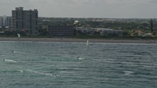 AX0031_167E - 5K aerial stock footage of flying by kite surfers, Pompano Beach, Florida