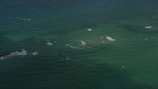 AX0031_177 - 5K aerial stock footage of flying over kite surfers near the shore, Pompano Beach, Florida