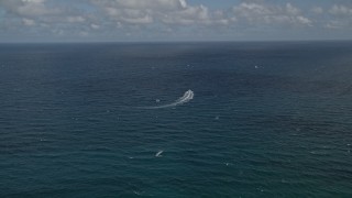 AX0031_180 - 5K aerial stock footage of following speedboat cruising on the Atlantic, Pompano Beach, Florida