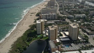 AX0031_183 - 5K aerial stock footage of orbiting apartment buildings on coast, Pompano Beach, Florida