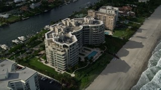 AX0032_011 - 5K aerial stock footage of following the beach, tilt down to condominium complex, Hillsboro Beach, Florida