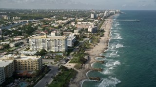 AX0032_015E - 5K aerial stock footage of following the coast toward a pier, Deerfield Beach, Florida