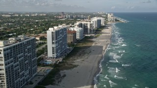 AX0032_018E - 5K aerial stock footage fly over sunbathers, beach, reveal apartment buildings, Boca Raton, Florida