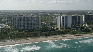 AX0032_031 - 5K aerial stock footage of flying by apartment buildings on the beach, Boca Raton, Florida