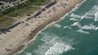 AX0032_044 - 5K aerial stock footage of flying by sunbathers on the beach, Delray Beach, Florida