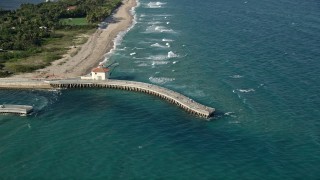 AX0032_055 - 5K aerial stock footage of approaching a pier by Boynton Beach Inlet, tilt down, Boynton Beach, Florida